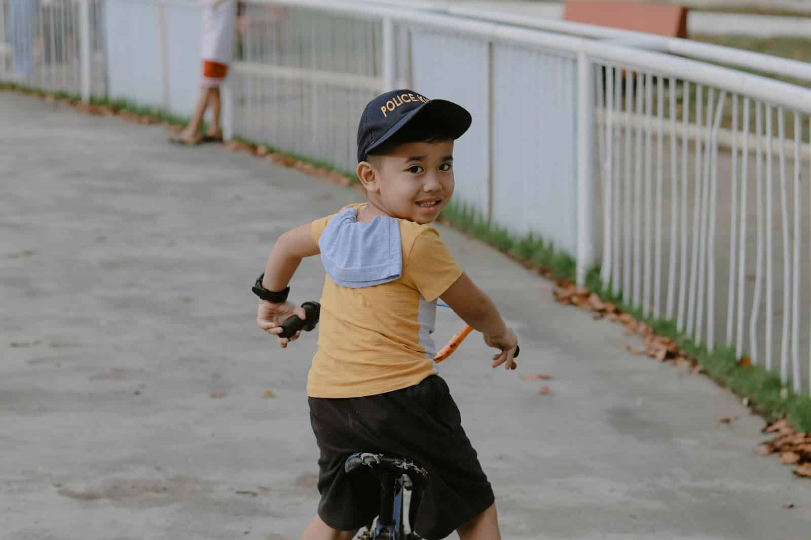 A young boy riding a skateboard down a sidewalk