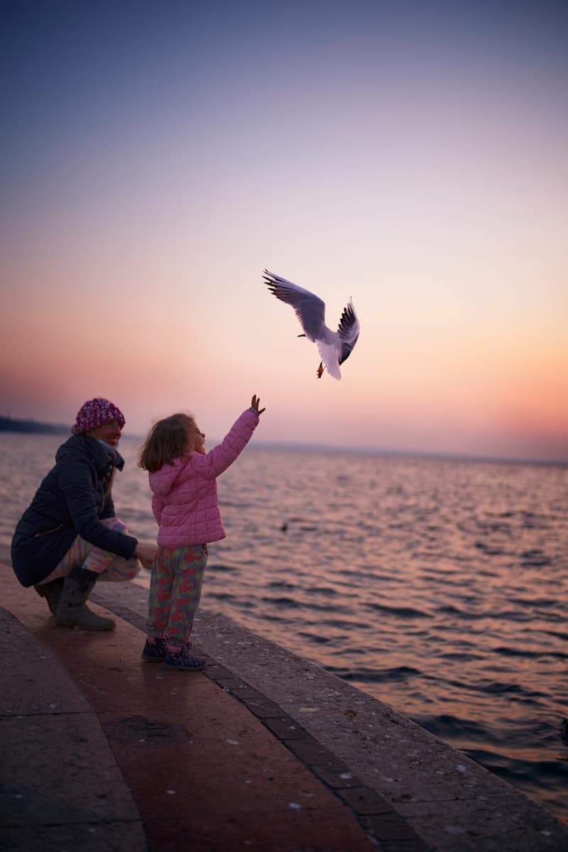 girl in pink jacket standing beside girl in black jacket and girl in pink jacket