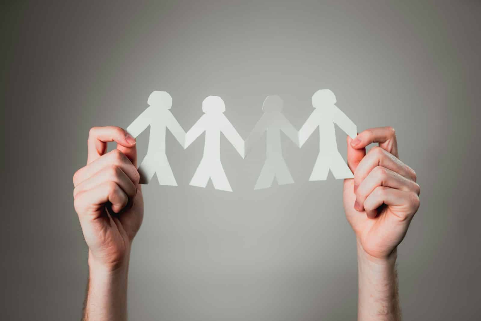 hands holding paper cutout family chain